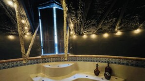 Un espace spa doté d’un jacuzzi à plusieurs niveaux, d’un éclairage décoratif et offrant une vue sur l’extérieur.