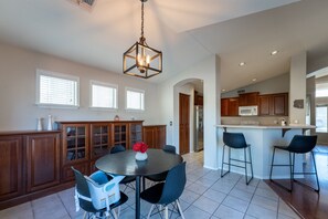 A spacious kitchen with a central island, wooden cabinets, and a dining area with chairs and a table. - 4-bedroom kid friendly home with HEATED Pool!  (gilbert)