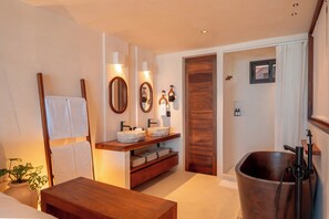 A modern bathroom with a wooden vanity, two sinks, a large bathtub, and a mirror. - Hotel Boutique Casa Muuch Holbox (Isla Holbox)