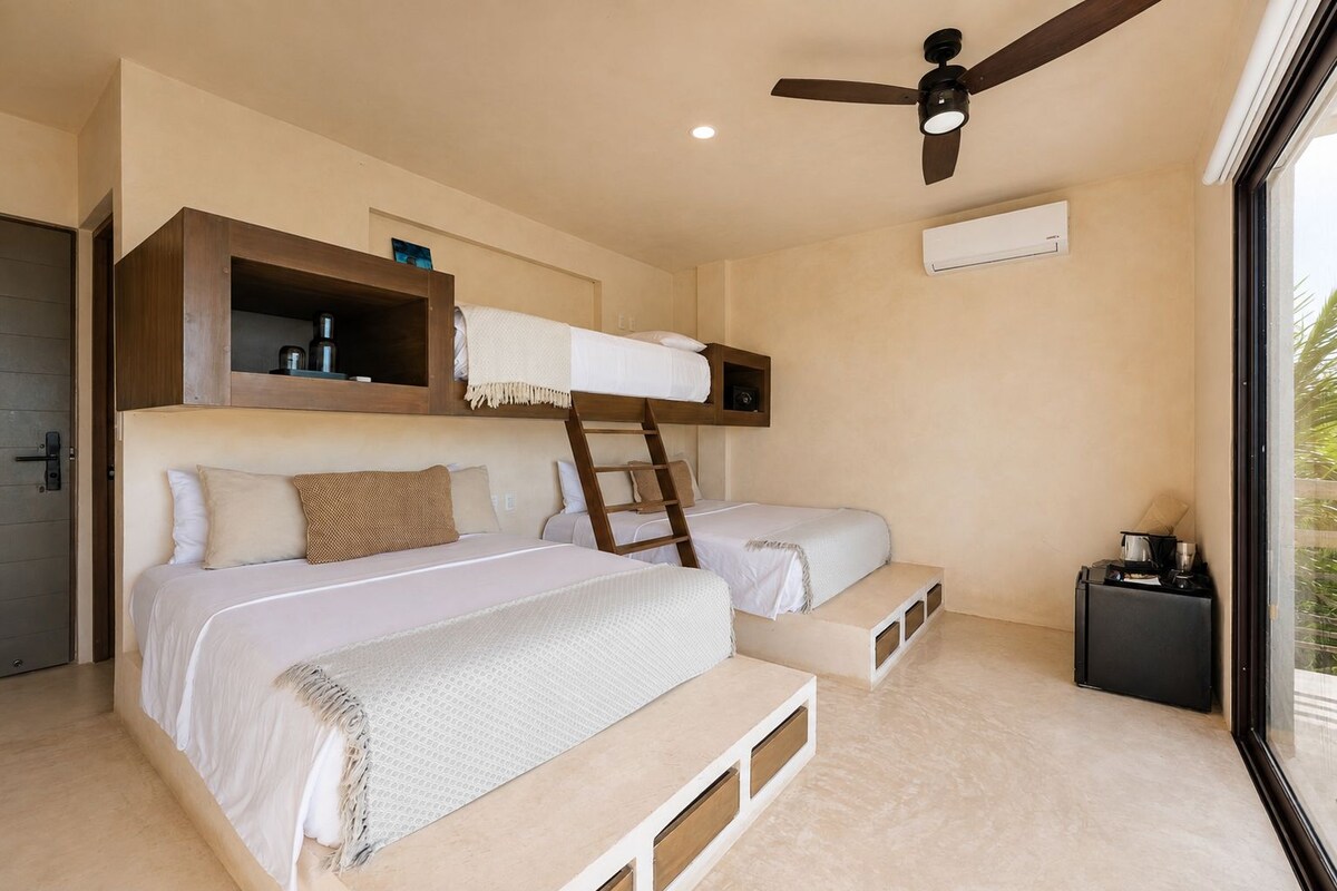 A bedroom with bunk beds, a ceiling fan, an air conditioning unit, and a window with a view.