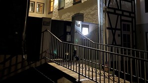 Un edificio de varios pisos con un estilo arquitectónico tradicional, que presenta vigas de madera a la vista y un balcón.