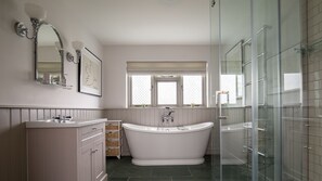Bathtub, rainfall showerhead, hair dryer, towels