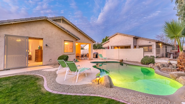 Ein Wohnhaus mit Schwimmbad, überdachter Terrasse und gepflegtem Rasen.