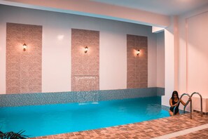 Una piscina al aire libre, sillones reclinables de piscina