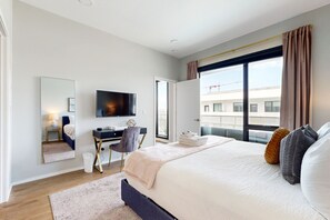 Relax in a spacious room with a large bed, flat-screen TV, and city view.