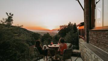 A patio with a table and chairs overlooking a scenic view.