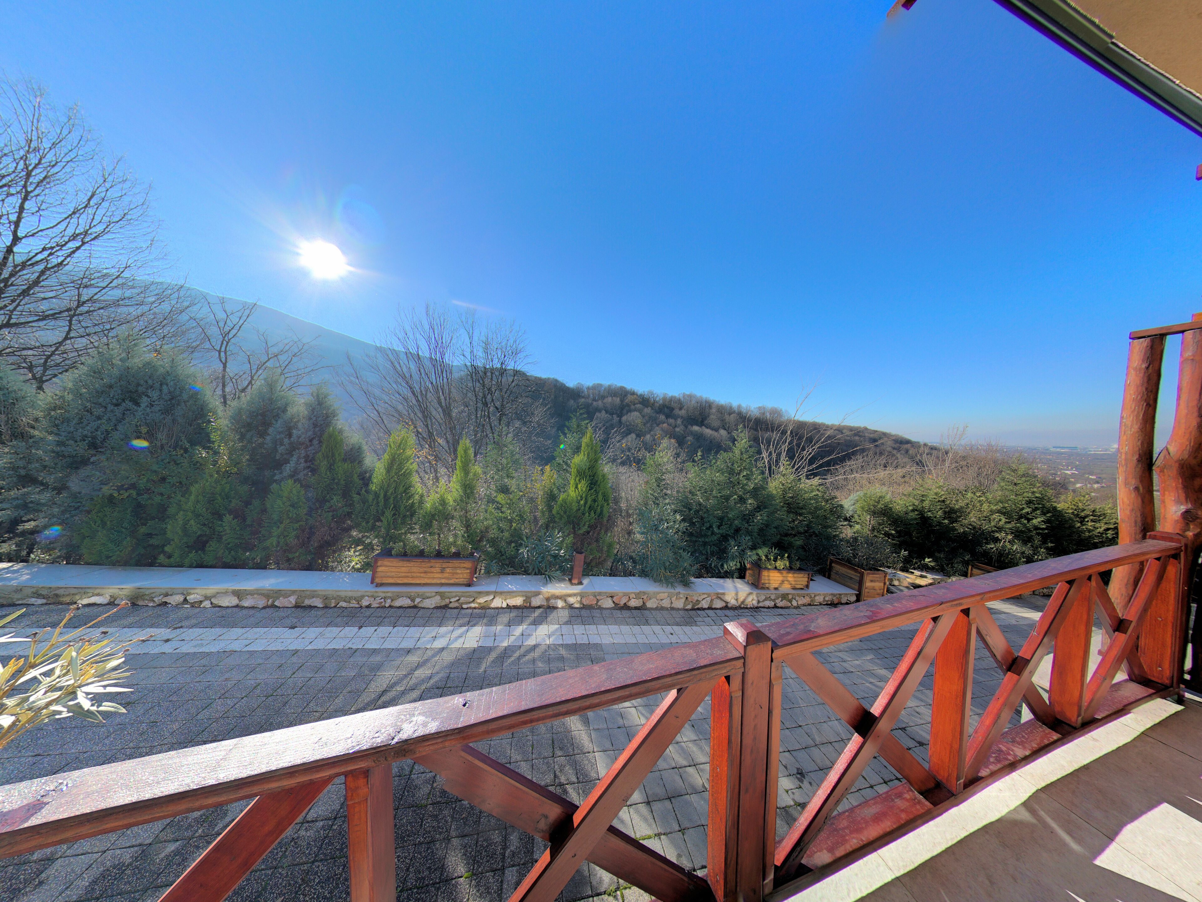 A wooden deck with a view of a mountainous landscape.