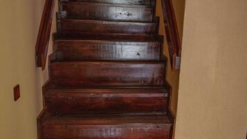 Una escalera de madera con barandilla que lleva a un piso superior.