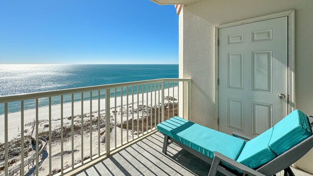 Ein Balkon mit Blick auf Strand und Meer.