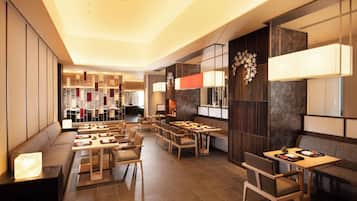 A modern restaurant with multiple seating areas, including a bar and a dining room.