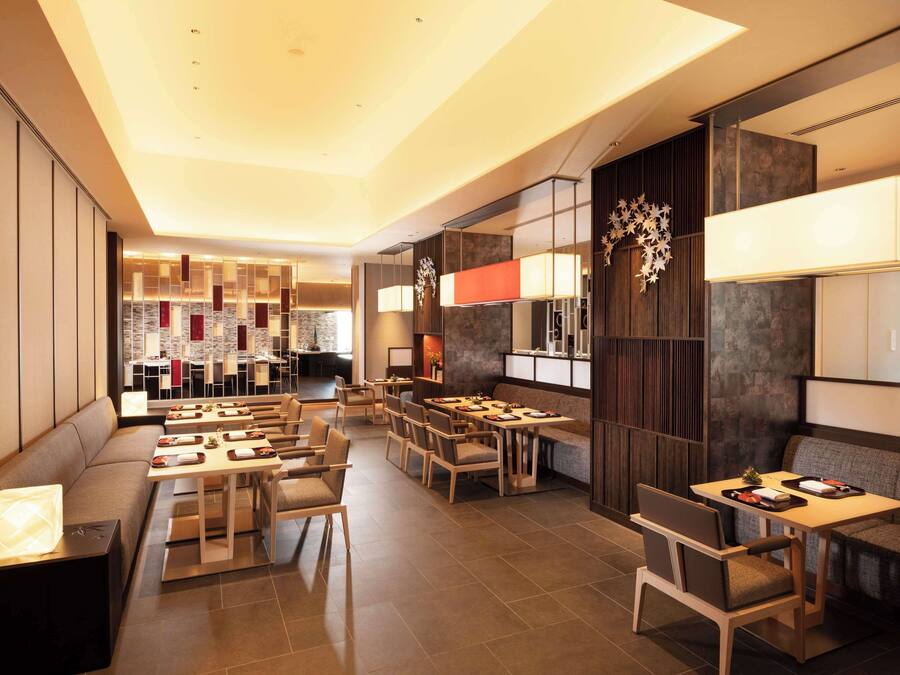 A modern restaurant with multiple seating areas, including a bar and a dining room.