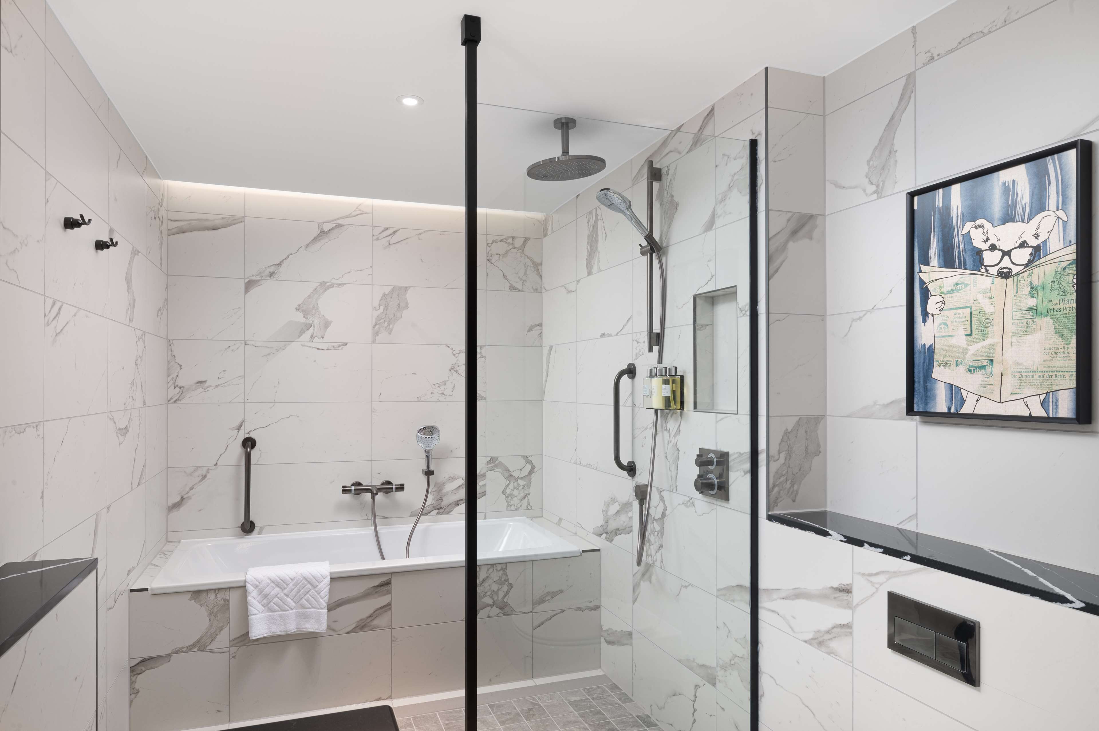 A modern bathroom with a glass-enclosed shower, a freestanding bathtub, and marble walls.