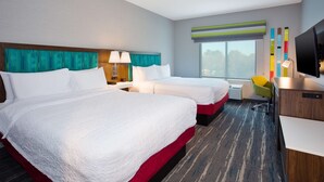 A hotel room with two beds, a desk, a chair, a TV, and a window with a view. - Hampton Inn By Hilton Paris (Paris)