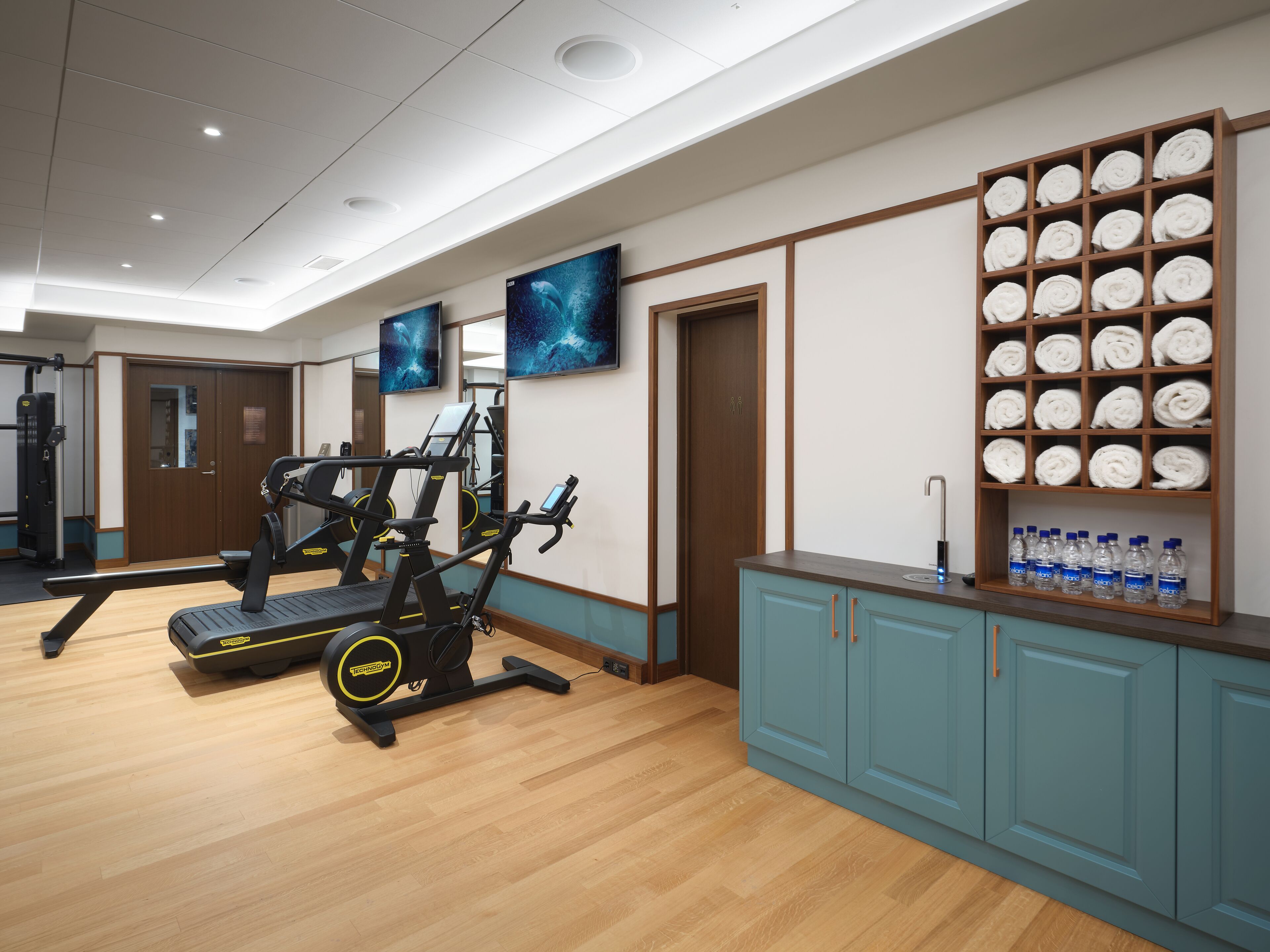A gym with treadmills, a weight machine, and a water station.