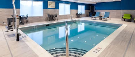 An indoor swimming pool with clear signage, including "NO LIFEGUARD ON DUTY" and "NO DIVING" warnings.