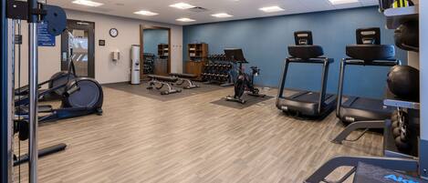 A gym with treadmills, elliptical machines, and weightlifting equipment.
