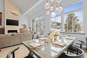 Enjoy meals with friends and family in the spacious dining area, featuring a fireplace and a large window with a view.