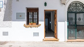 A white building with a window, a door, and a green gate. - Apartment El Cotarro B  (Vejer de la Frontera)
