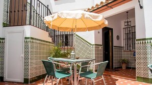 An outdoor patio with a table and chairs, a yellow umbrella, and a staircase. - Apartment El Cotarro A  (Vejer de la Frontera)