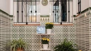 A tiled courtyard with a number sign, potted plants, and a tiled floor. - Apartment El Cotarro A  (Vejer de la Frontera)