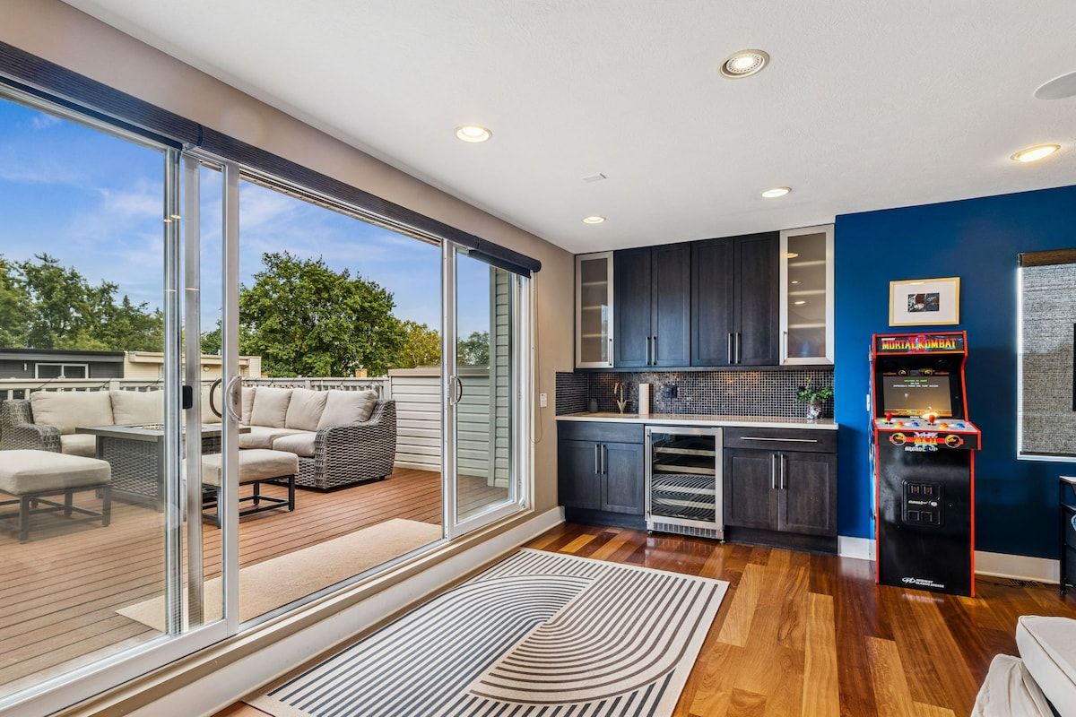 A modern kitchen with dark cabinets, a microwave, and a neon sign.