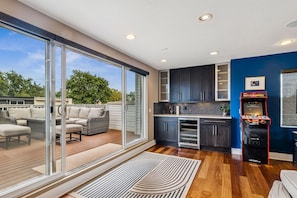A modern kitchen with dark cabinets, a microwave, and a neon sign.