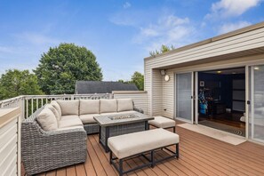 A deck with a sofa, a table, and a bench.