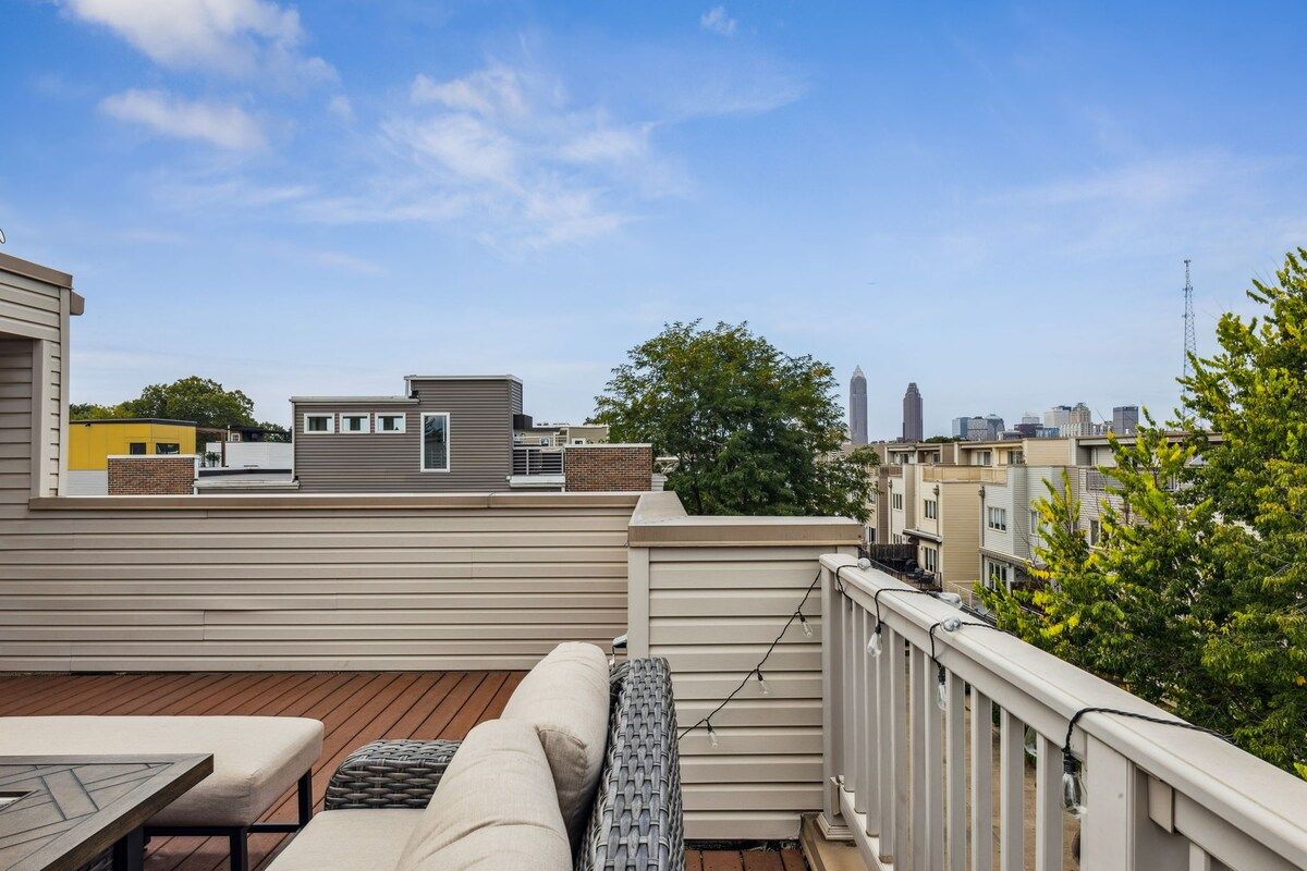 Eine Dachterrasse mit einer Couch, einem Tisch und einem Geländer.