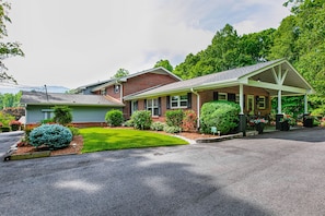 Stroll through the beautifully landscaped grounds of this charming two-story home, featuring a spacious porch and a paved driveway.