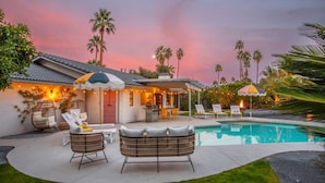 A poolside area with lounge chairs, a covered seating area, and a pool. - Colorful Modern Luxury w/ Stunning Mountain Views (Palm Springs)