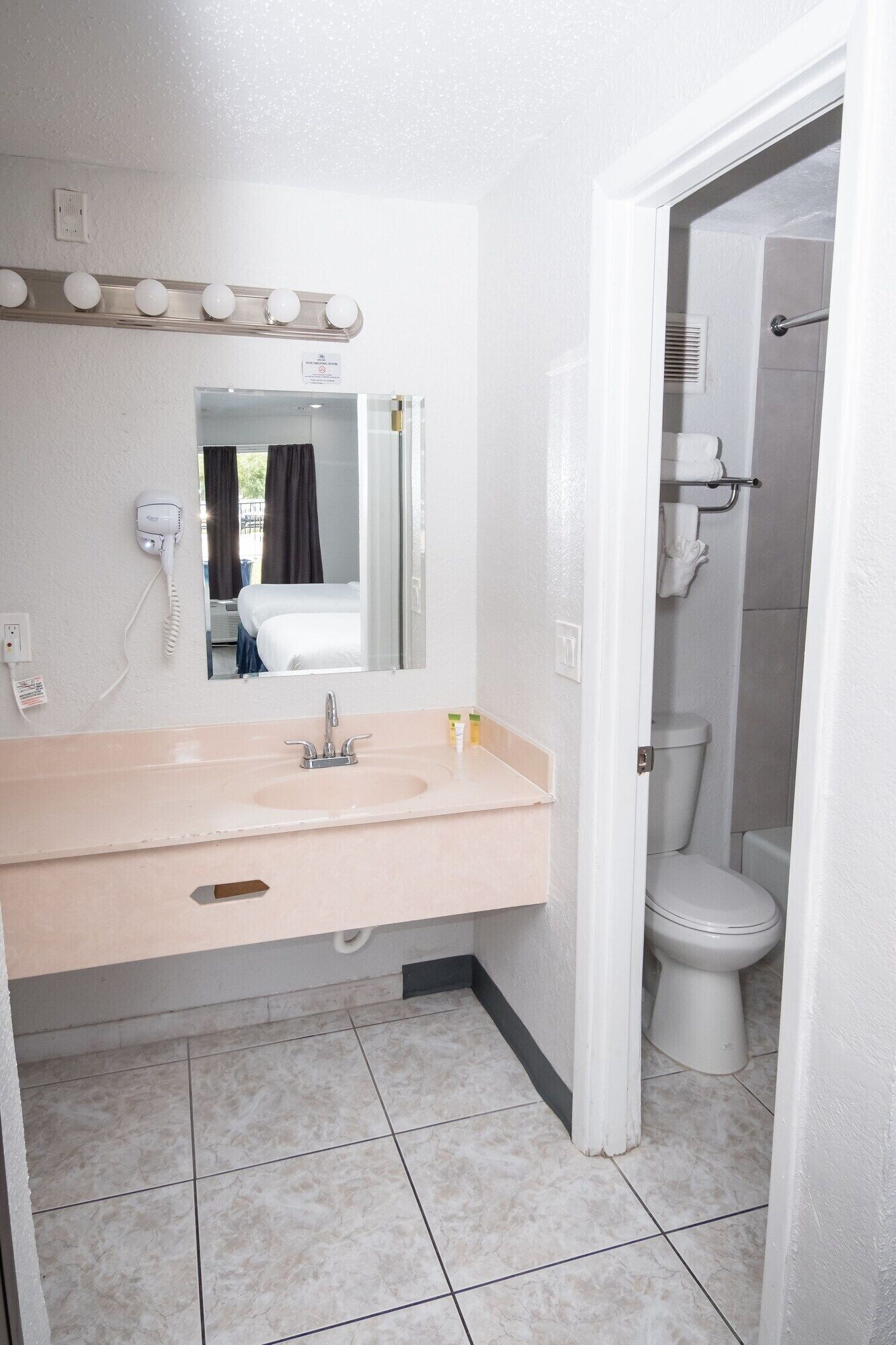 Une salle de bain avec un lavabo, un miroir et des toilettes.
