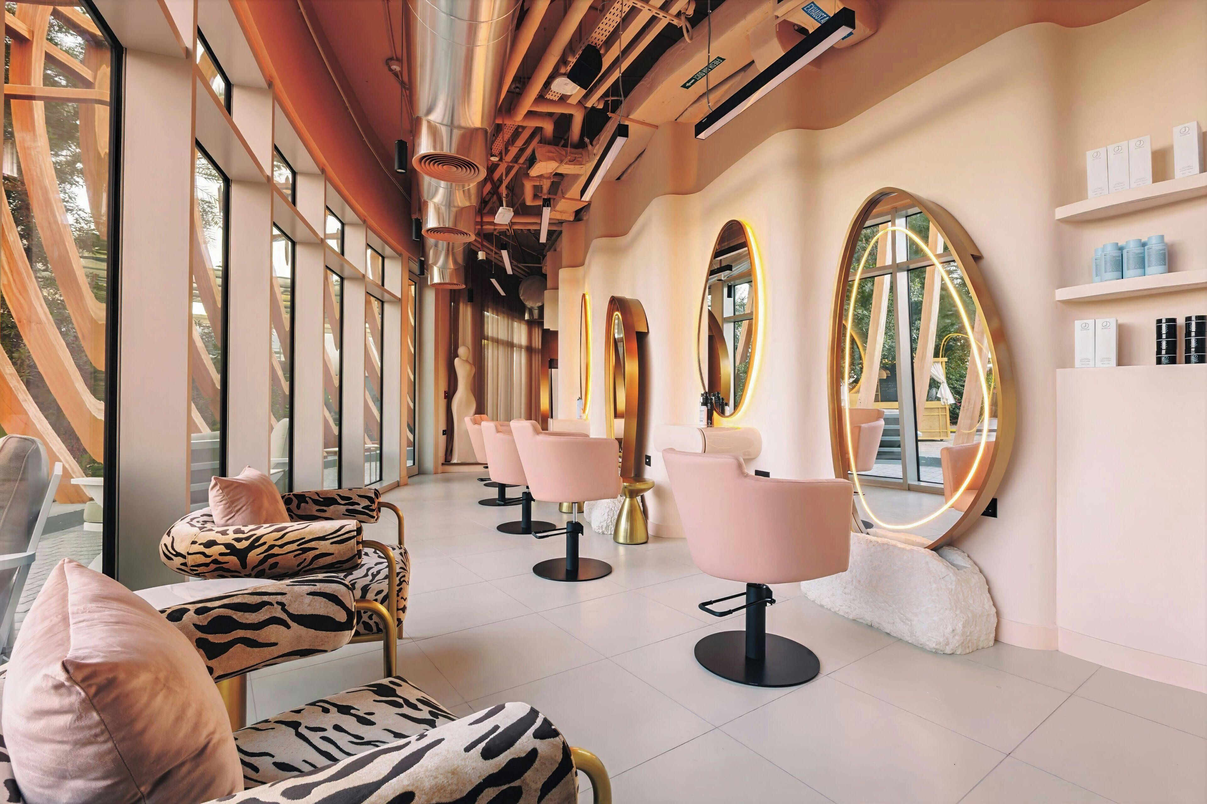 A modern salon with large mirrors, plush seating, and a clean, well-lit interior.