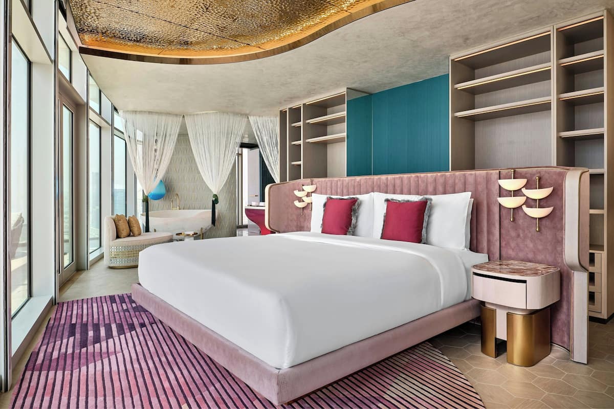 Une chambre moderne dotée d’un grand lit, d’étagères intégrées et offrant une vue dégagée grâce à de grandes fenêtres.