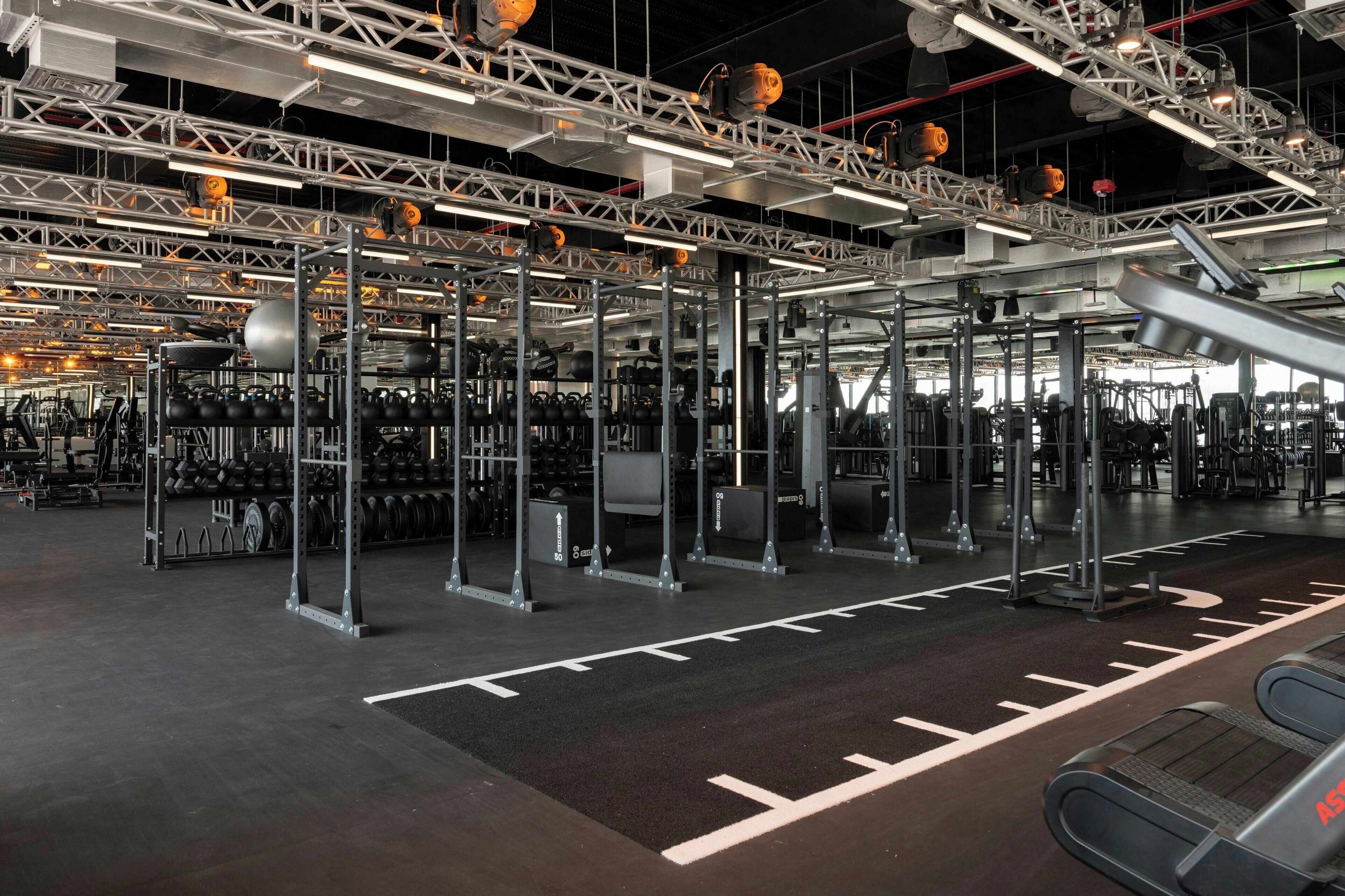 A gym with various exercise equipment, including weight racks and cardio machines.