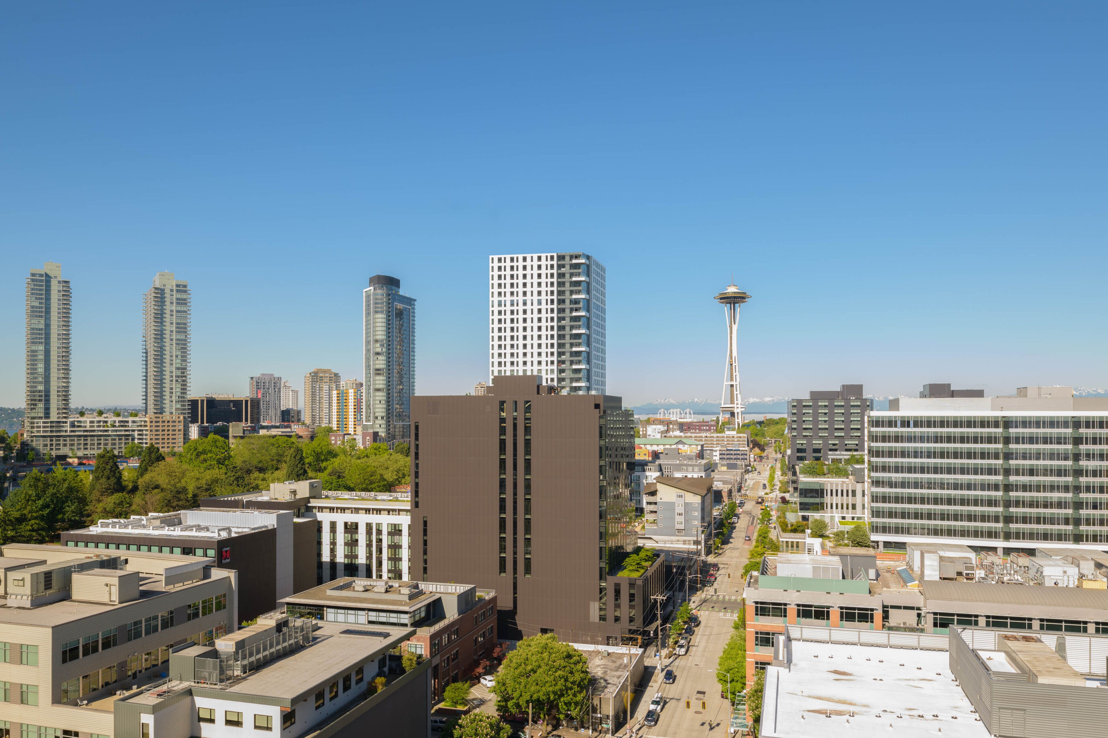Un paysage urbain caractérisé par des immeubles modernes de grande hauteur, une tour imposante et un mélange de bâtiments commerciaux et résidentiels.