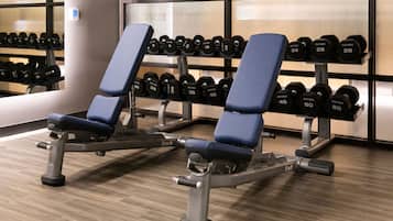 Une salle de sport équipée de matériel de musculation et d’haltères.