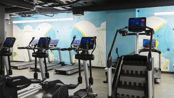 A gym with treadmills, ellipticals, and a rowing machine.