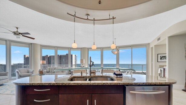 A modern kitchen with a large island, stainless steel appliances, and a view of the ocean. - Bella Luna 810-Spectacular Views of Beach & Bay (Orange)