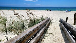 A beach with a wooden fence, clear blue sky, and calm sea. - Bella Luna 810-Spectacular Views of Beach & Bay (Orange)