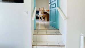 A staircase leading to a dining area with a table and chairs. - Bonaparte (Bains-les-Bains)