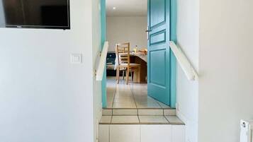Un escalier menant à une salle à manger équipée d’une table et de chaises.