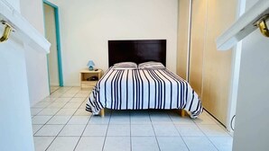 A bedroom with a bed, a nightstand, a lamp, and a wardrobe. - Bonaparte (Bains-les-Bains)