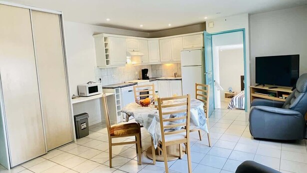 A modern apartment with a dining area, kitchen, and living room. - Bonaparte (Bains-les-Bains)