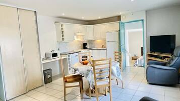 Un appartement moderne comprenant un coin repas, une cuisine et un salon.