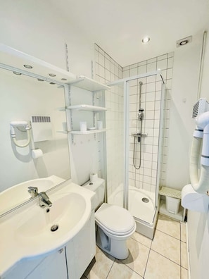 Et moderne badeværelse med vask, toilet og bruser.