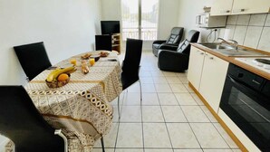 A modern kitchen with a dining area, a TV, and a view to the outside. - Victor Hugo (Bains-les-Bains)