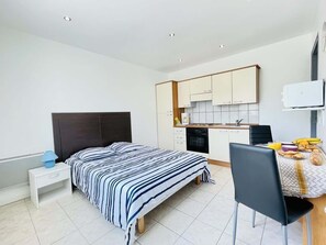 A bedroom with a bed, bedside table, and a small table with breakfast items. - Alfred De Musset (Bains-les-Bains)