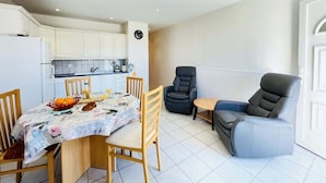 A compact living space with a dining area, kitchenette, and seating area. - Athos (Bains-les-Bains)