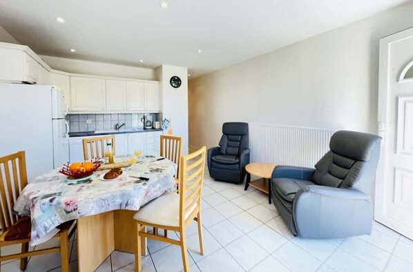 Un espacio habitable pequeño con comedor, kitchenette y zona de estar.
