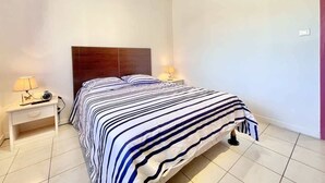 A bedroom with a bed, two bedside tables, and a nightstand. - Athos (Bains-les-Bains)